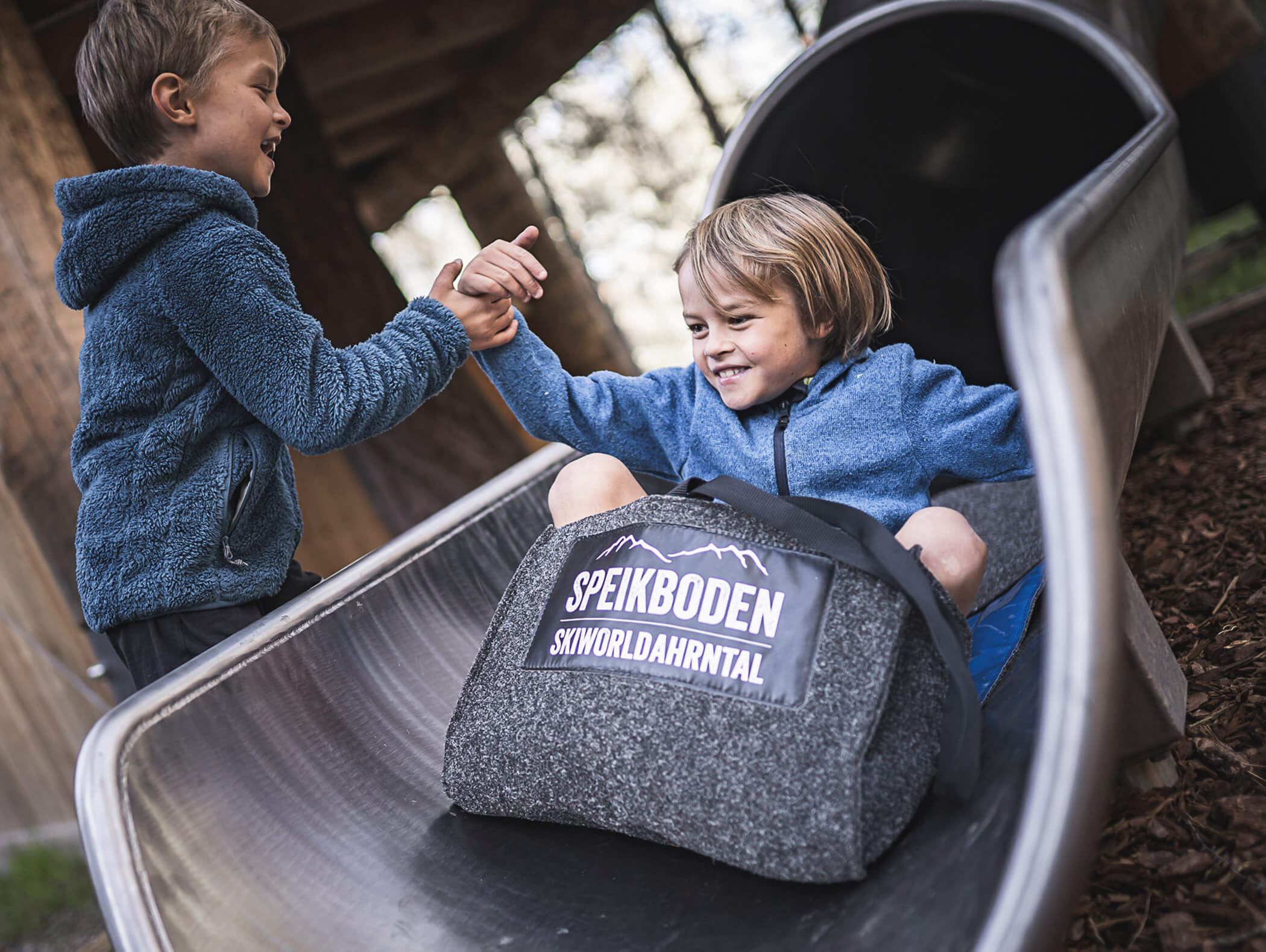 Un ragazzo aiuta un altro ragazzo a uscire dallo scivolo nella valle Skiwordahrntal a Speikboden - Pensione Oberwirt