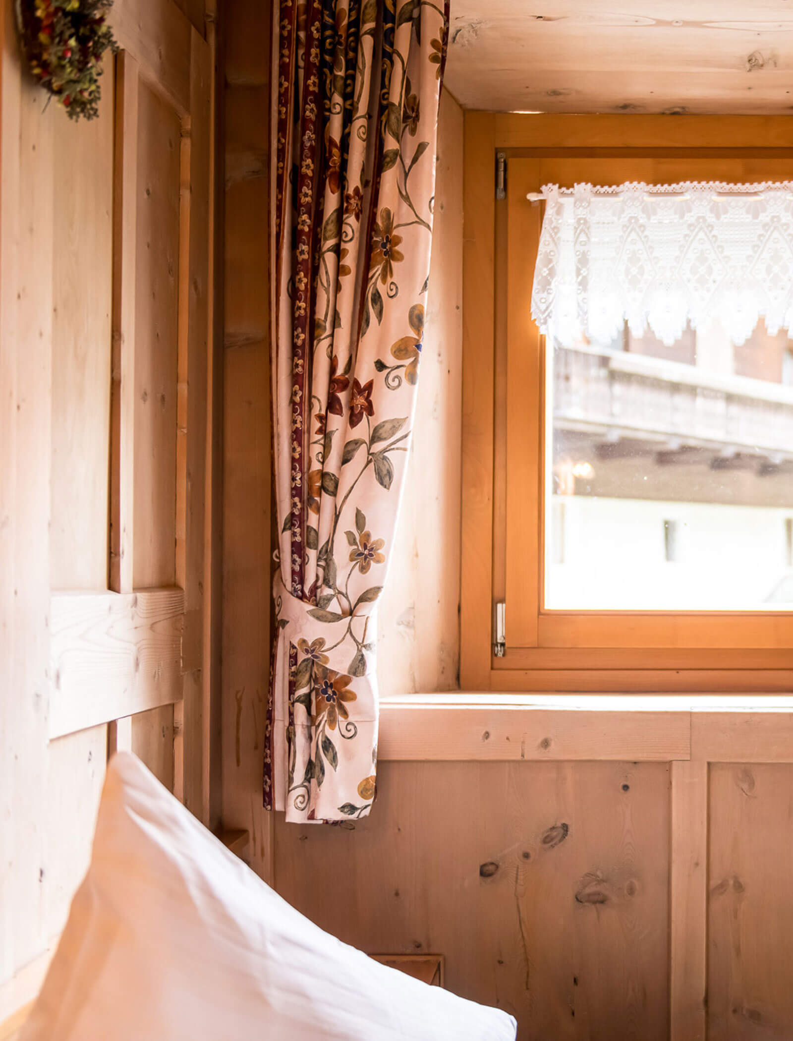 White cushion with curtain and window in the background - Pension Oberwirt