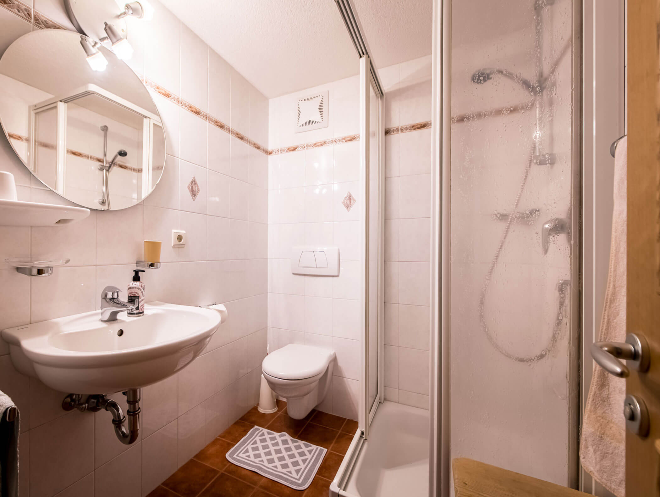 Bagno in camera comune con lavabo, specchio, WC e doccia - Pensione Oberwirt